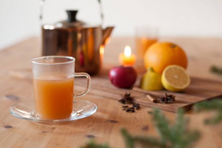 De warme appelpunch wordt geserveerd in een theeglas.