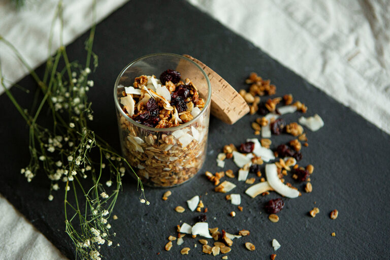 Zelfgemaakte granola staat in een klein potje op een leistenen plaat.