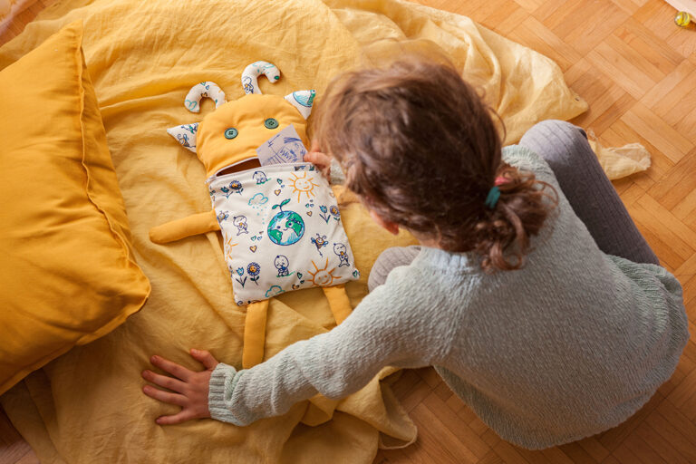 Kind zit naast een zorgenvriendje en stopt een briefje in zijn mond