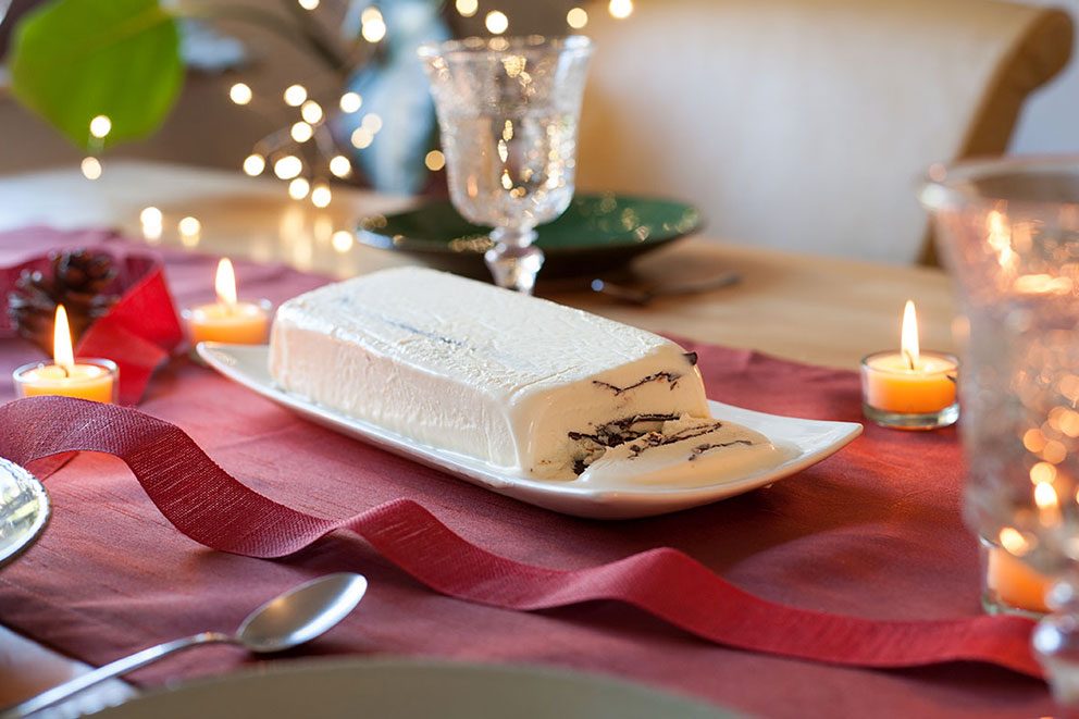 De parfait staat aangesneden op een feestelijk gedekte tafel.