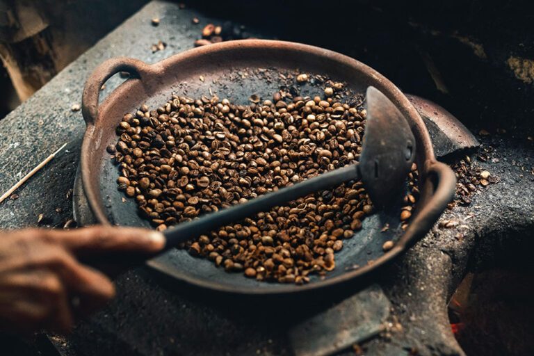 Koffiebonen worden in een pan gebrand.