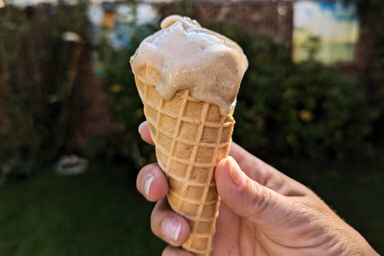 Zelfgemaakte Nicecream in een wafel wordt met één hand vastgehouden.