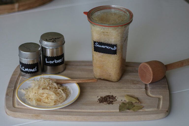 Das selbst gemachte Sauerkraut ist in einem Einmachglas und auf einem Teller zu sehen.