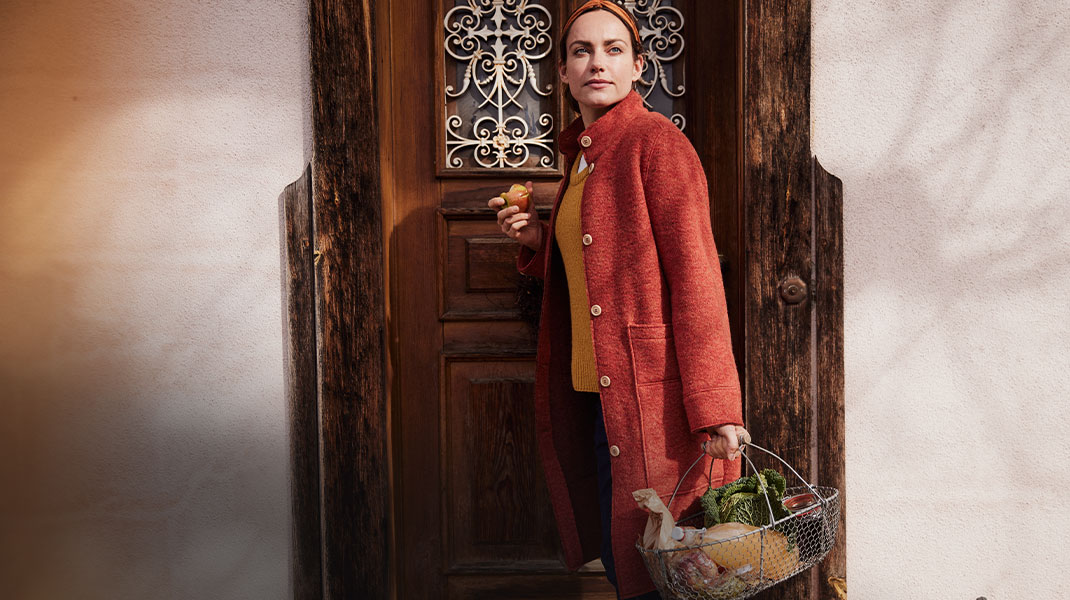 Vrouw gekleed in natuurlijke mode keert terug van boodschappen doen.