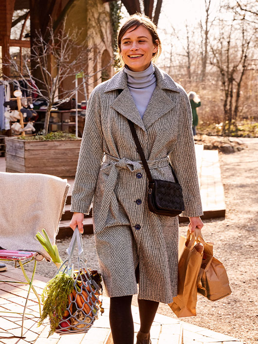 Vrouw in een mantel van bio-wol bij het shoppen