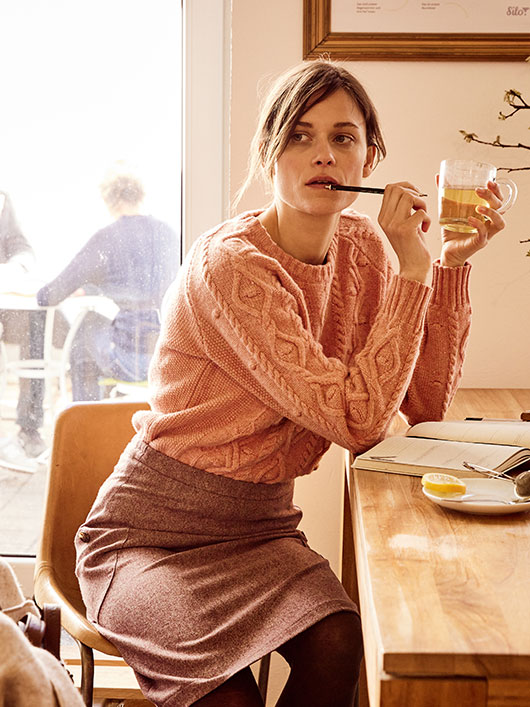 Vrouw in een bio-pullover in een café