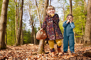 Meisje en jongen in het bos dragen herfstmode gemaakt van bio-walkstof