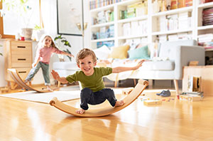 Kinderen op een balanceboard in de woonkamer