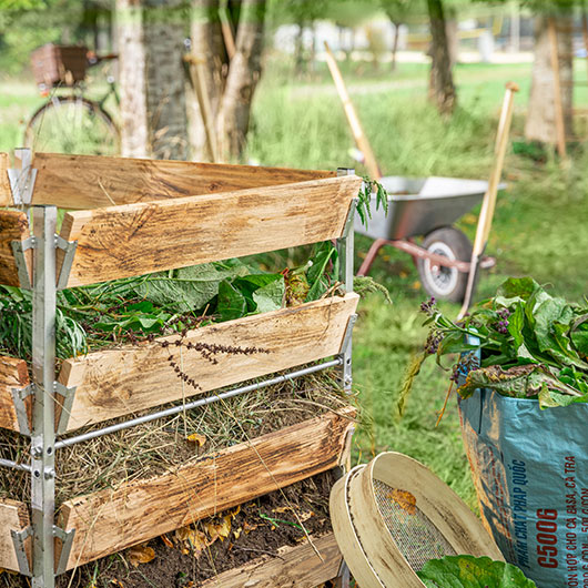Gevulde houten compostbak in een natuurlijke tuin