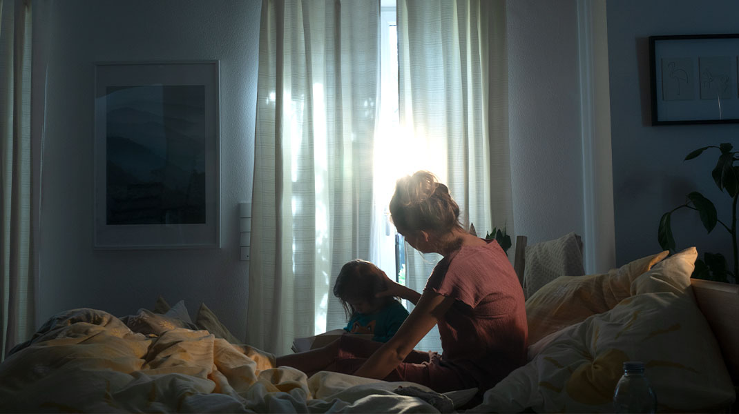 Moeder en kind worden 's morgens wakker in bed.