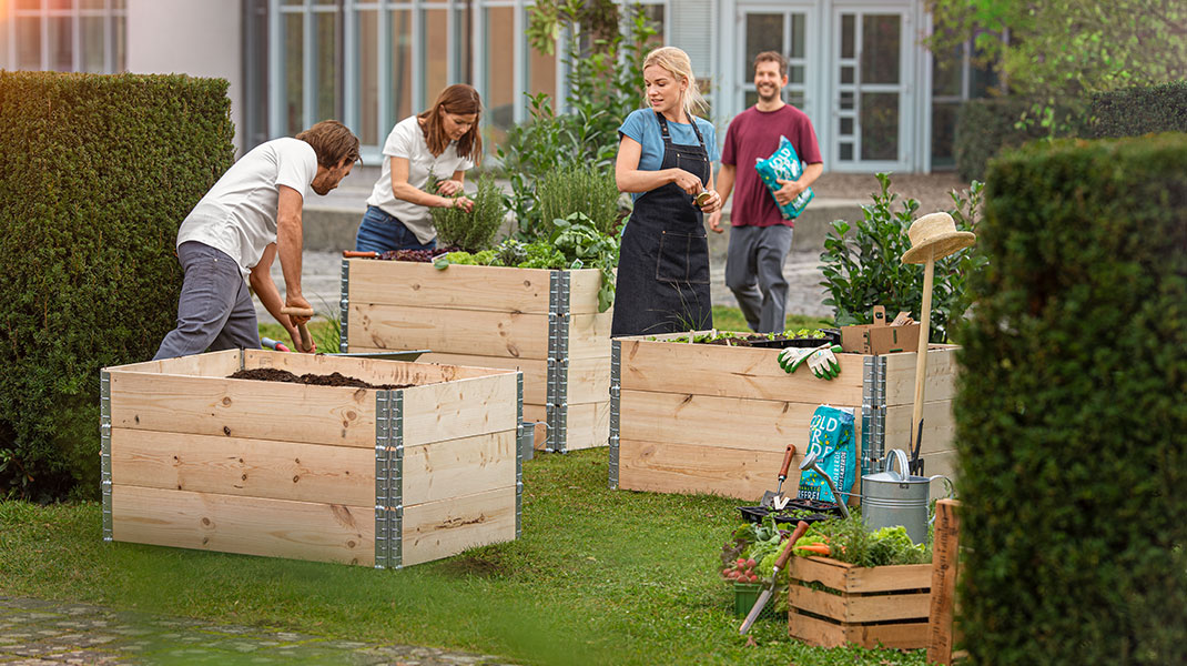 Moestuinbakken aan de voorkant van het kantoorgebouw worden beplant