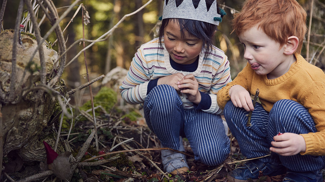 Kinderen in stoere kleding spelen in het bos