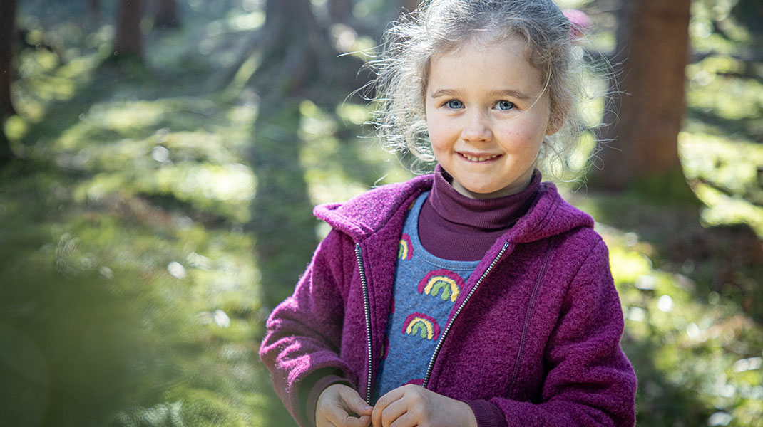 Meisje in het bos draagt zachte en duurzame, biologische kleding van walkstof