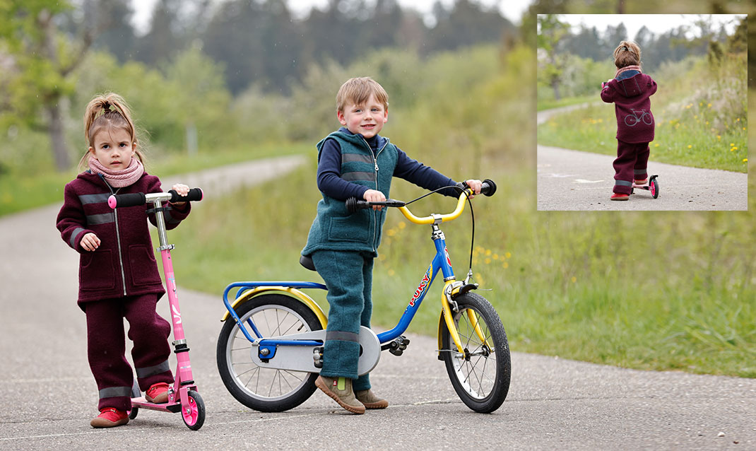 Kinderen met een step en fiets in bio-walkstofmode met reflectoren.