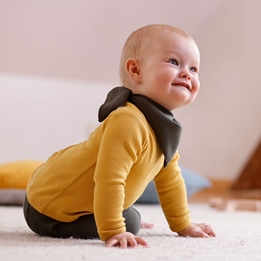 Baby in een geel ripshirt met lange mouwen van Waschbär