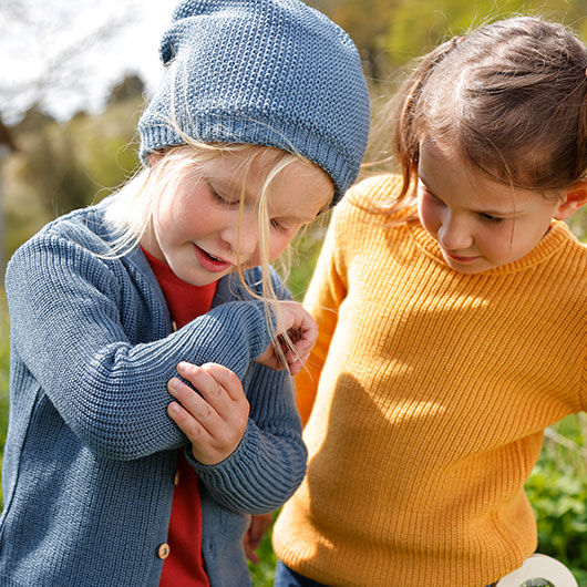 Jongen en meisje in kleurrijke en comfortabele trui en vest buiten in de frisse lucht