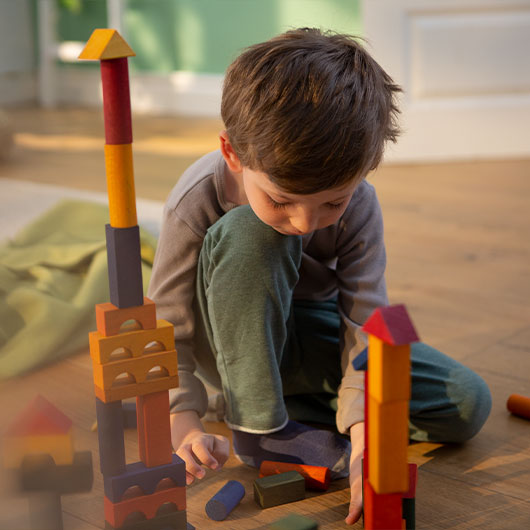 Jongen speelt met natuurlijke blokken van hout