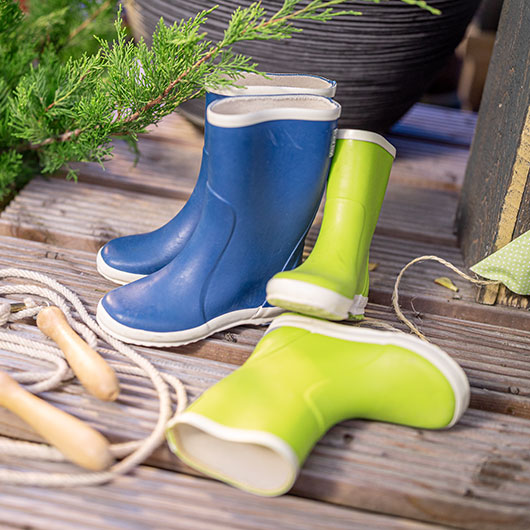 Groene en blauwe kinderregenlaarzen met een springtouw