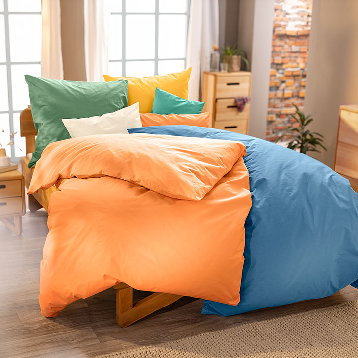 Comfortabel bed met kleurrijke dekbedovertrekken van bio-katoen