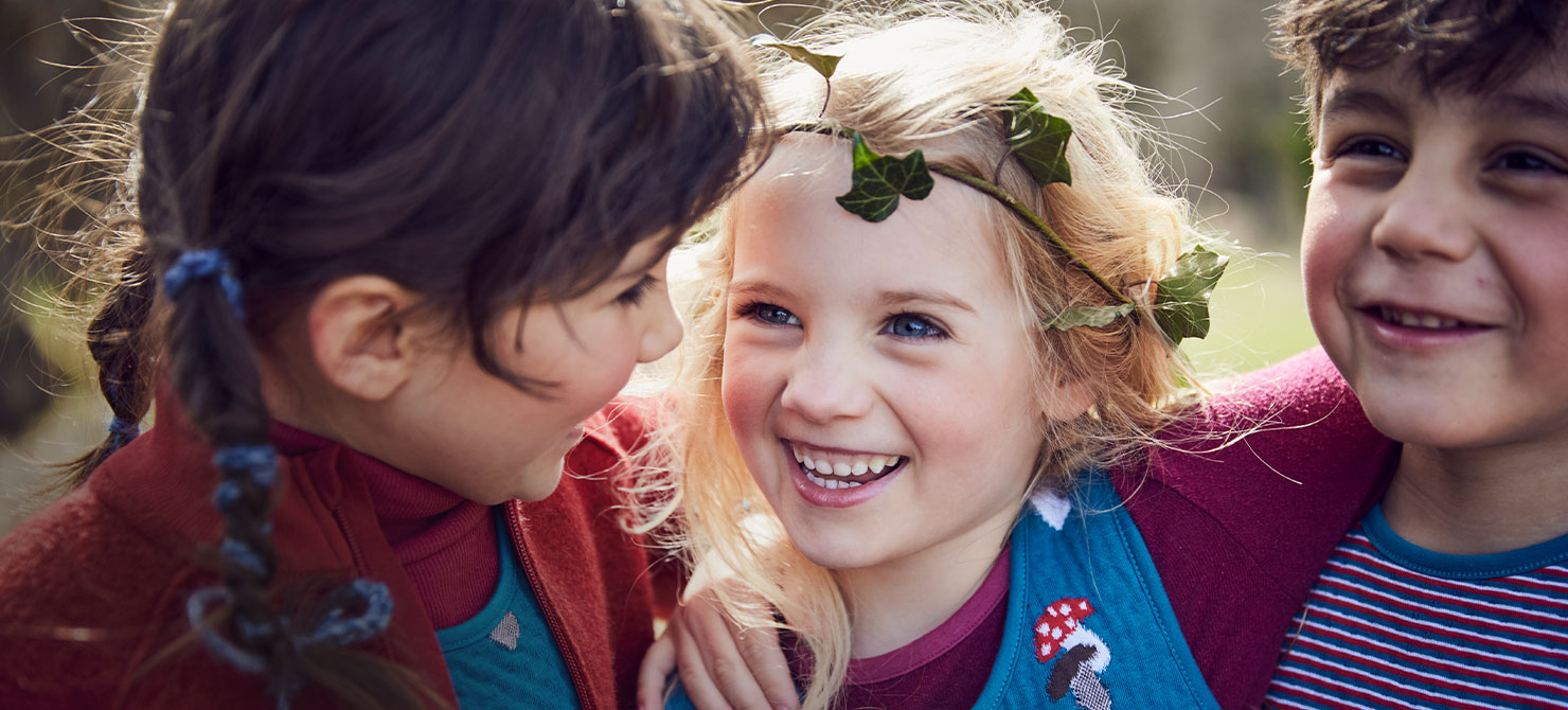 Lachende kinderen in biologische herfstmode