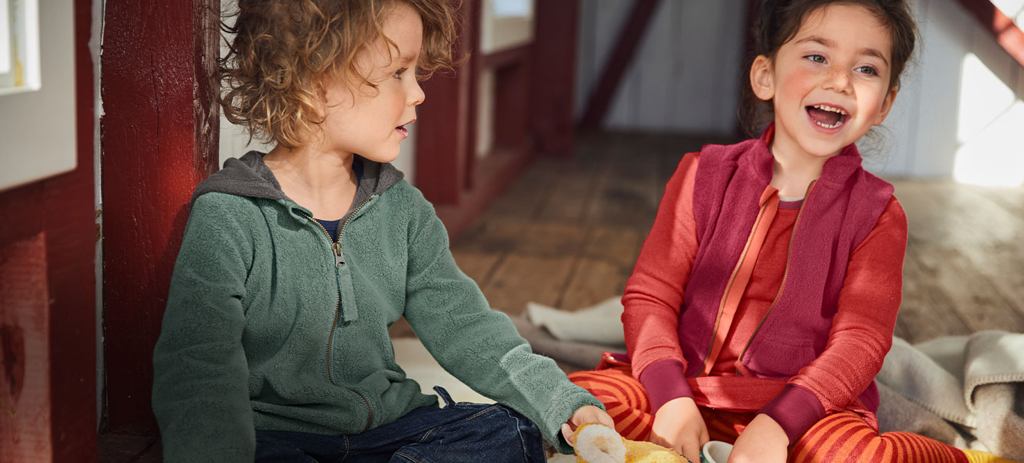 Lachende kinderen in biologische herfstmode