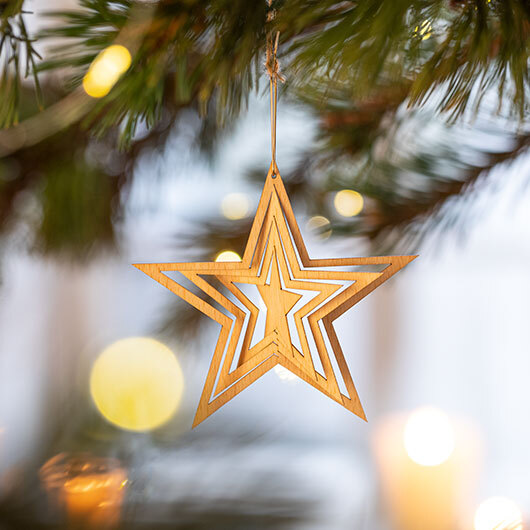Houten ster hangend aan een kerstboom