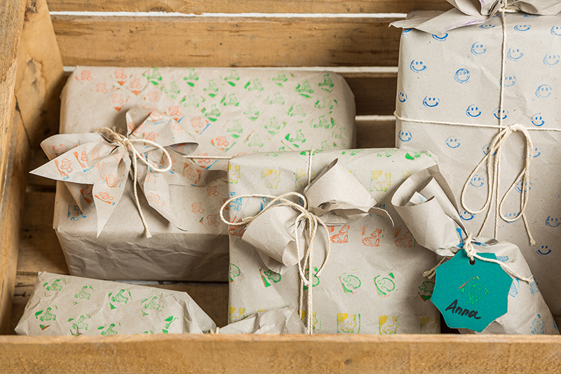 Ingepakte cadeautjes in een kist. Ingepakte cadeautjes met zelfgemaakt cadeaupapier in een kist.